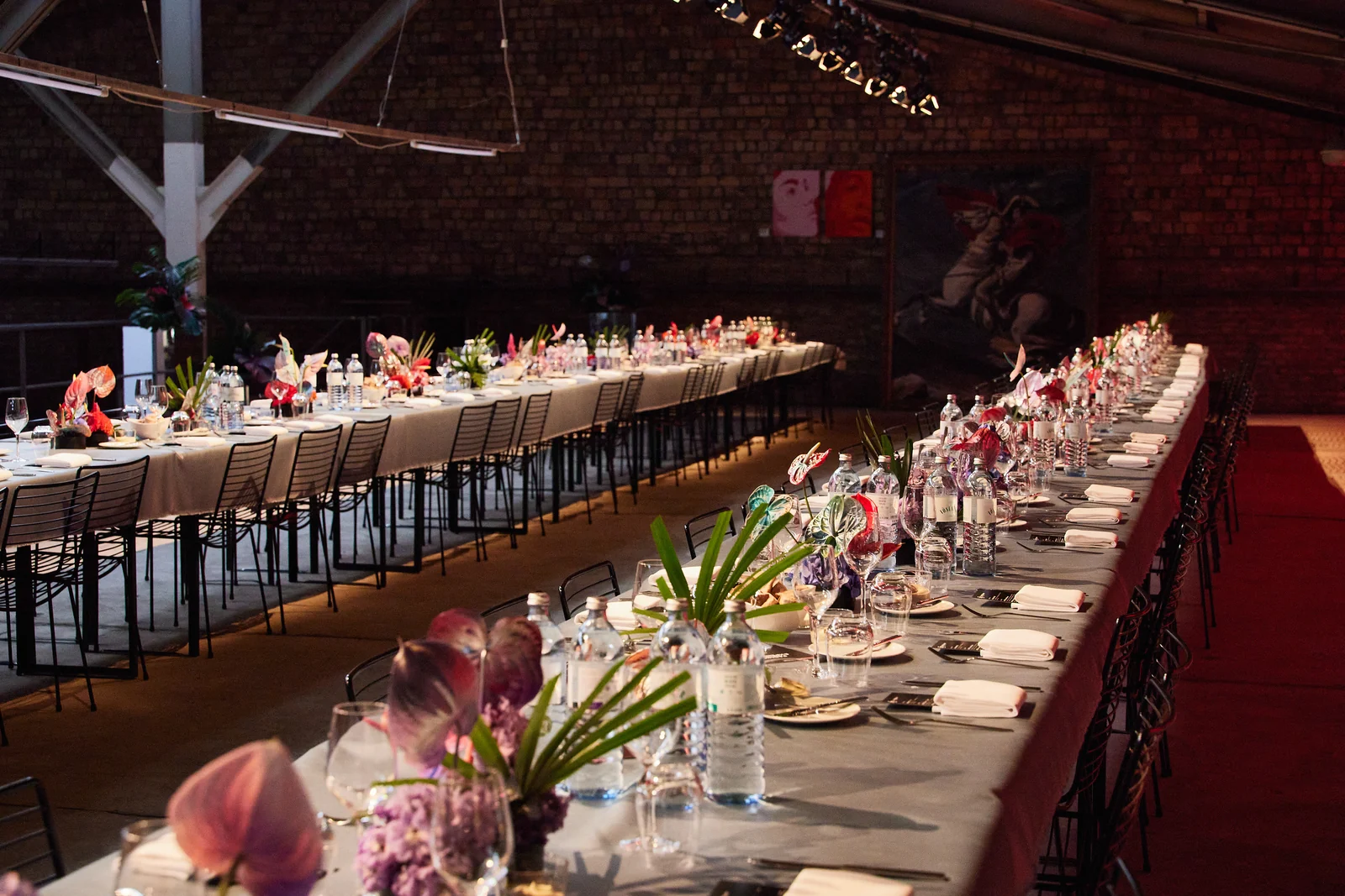 Long-Table-Dinner im Komplex Berlin mit Blumendekoration und Backsteinwänden