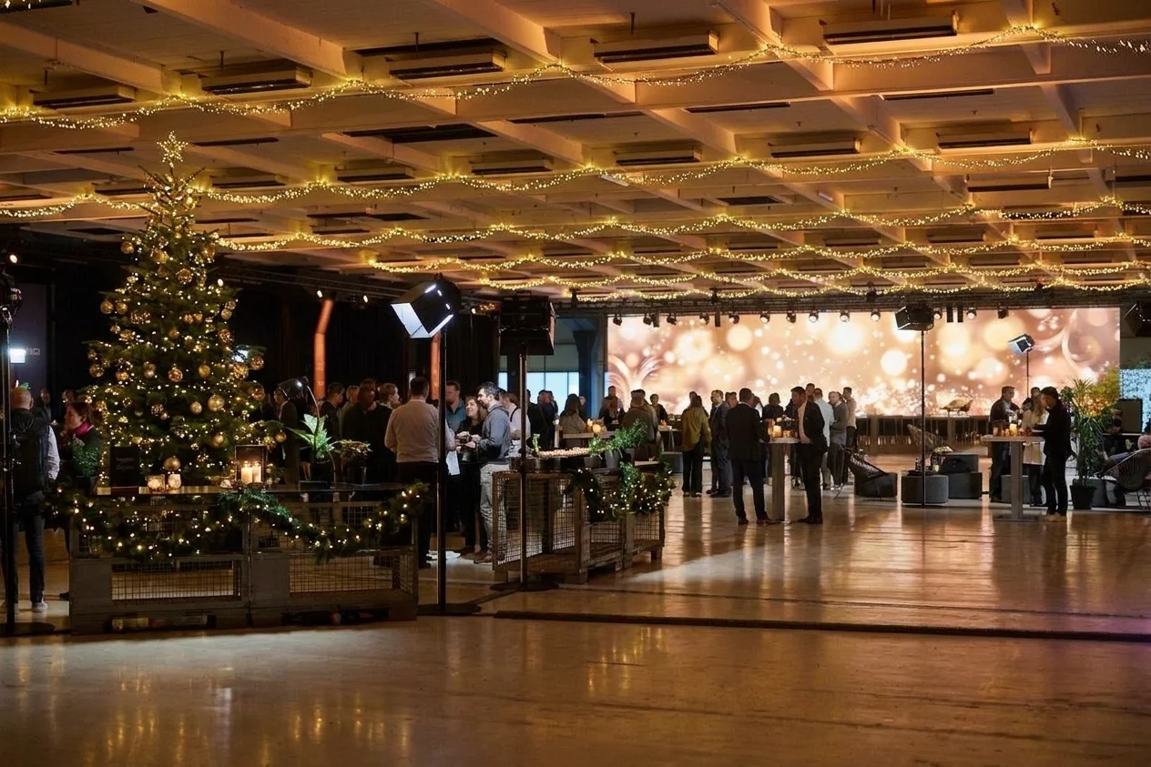 Weihnachtlicher Empfang in Bay 7 im NLND mit Lichterketten, Weihnachtsbaum und LED-Wand